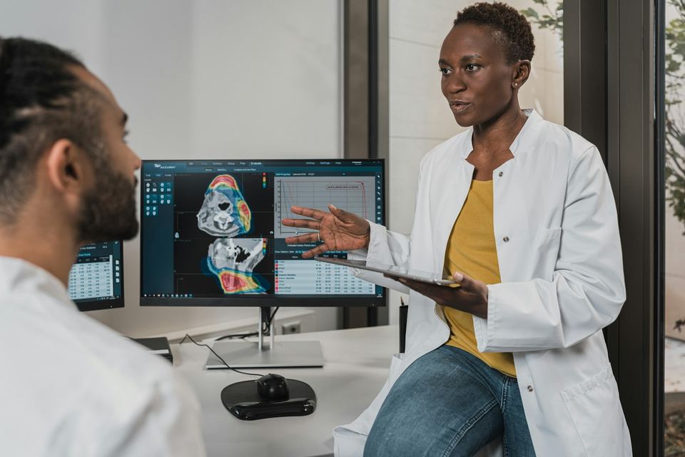 Two clinicians reviewing patient information together at a workstation in a modern clinic